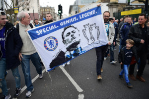 Supporters carry a flag in support of Chelsea's former Portuguese manager Jose Mourinho before the English Premier League football match between Chelsea and Sunderland at Stamford Bridge in London on December 19, 2015. Jose Mourinho attended the Championship match between Brighton and Hove Albion and Middlesbrough today in his first public appearance since being sacked as Chelsea manager on Thursday. AFP PHOTO / LEON NEAL / AFP / LEON NEAL (Photo credit should read LEON NEAL/AFP/Getty Images)